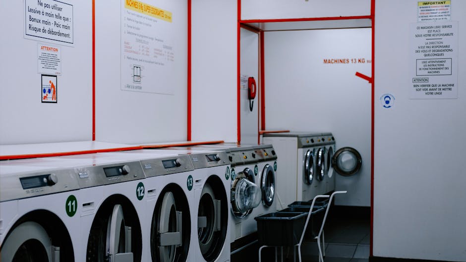 Commercial laundry facility with multiple dryers and washers highlighting the need for professional dryer vent cleaning services