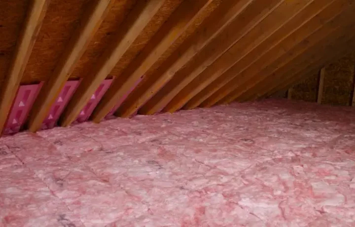 Fiberglass insulation laid out in an attic to enhance energy efficiency and comfort.