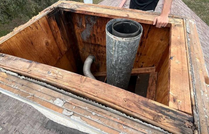 Repaired chimney structure with new crown and cap on residential roof.