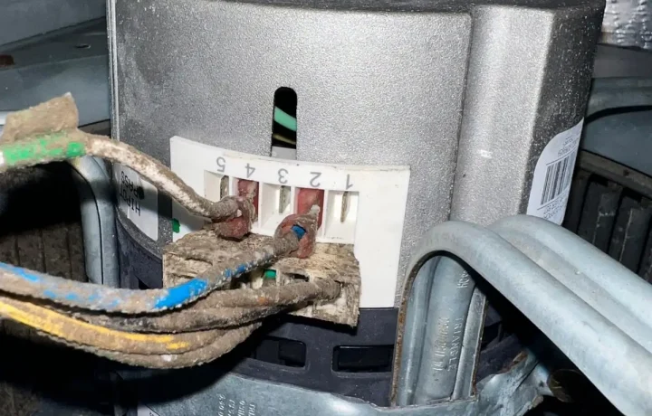 Close-up of an HVAC blower motor electrical plug showing dirt and corrosion on the wire leads.