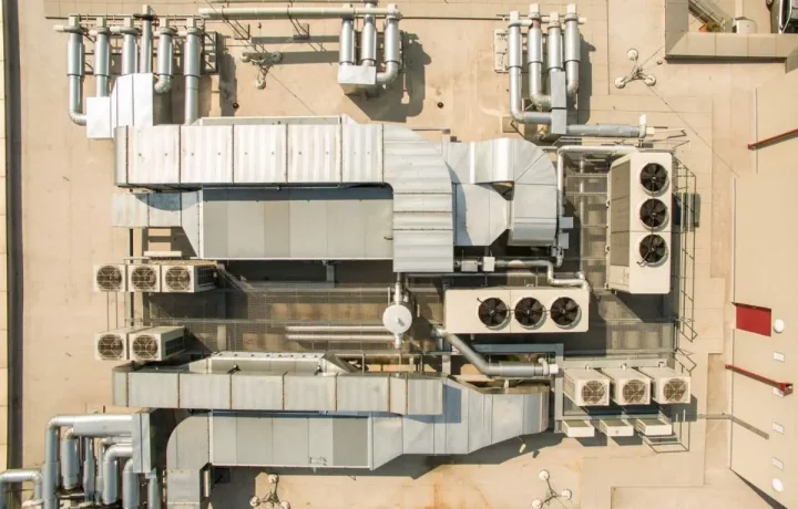 Aerial view of a commercial HVAC system with large ducts and air conditioning units on the roof of a building.