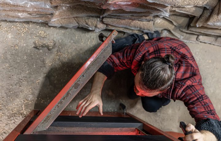 Young man inspecting a chimney fireplace for maintenance and cleaning.
